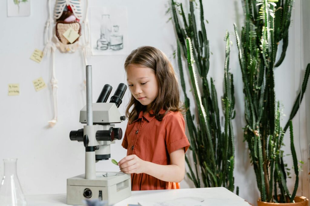 a smart girl using a microscope